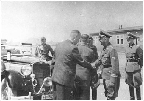 Reichsfuehrer SS Heinrich Himmler shakes hands [probably with an IG Farben representative] during a tour of the Monowitz-Buna building site.